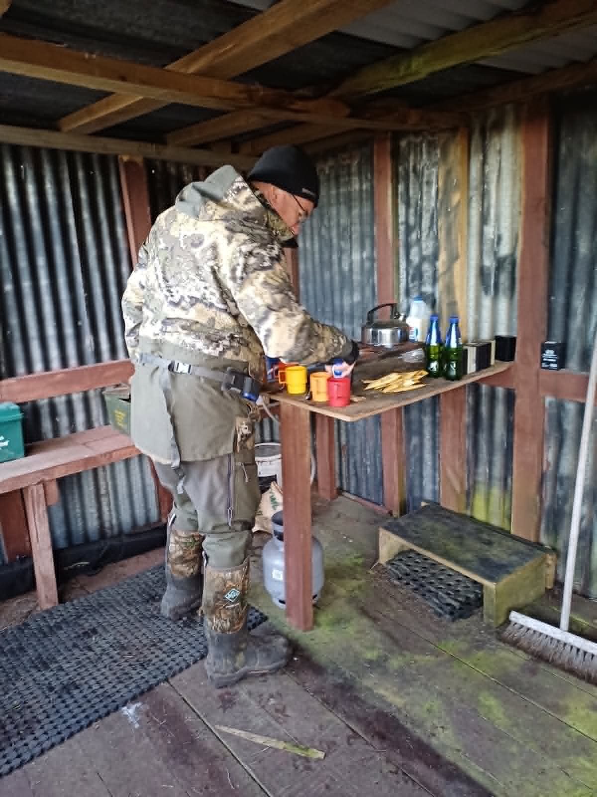 Marc making a hot drink on a cold duck hunting morning in New Zealand — warm layers and a thermos are essential
